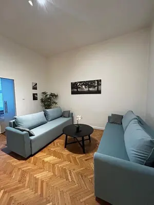a living room with two blue couches and a table at Small Market Square - Old Town in Kraków