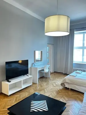 a bedroom with a bed and a tv and a desk at Small Market Square - Old Town in Kraków