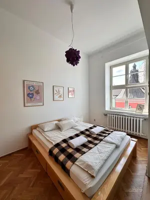 a large bed in a room with a window at Small Market Square - Old Town in Kraków