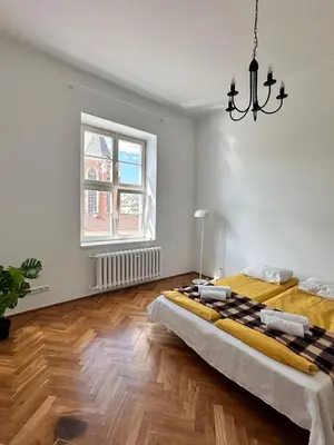 a bedroom with a large bed and a chandelier at Small Market Square - Old Town in Kraków