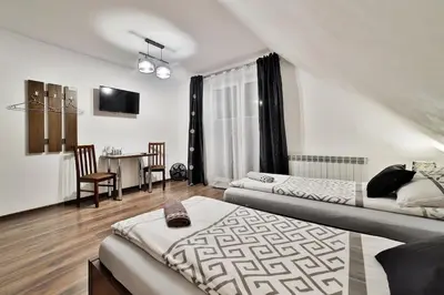 a living room with a bed and a dining room at Noclegi u Nawary in Rabka