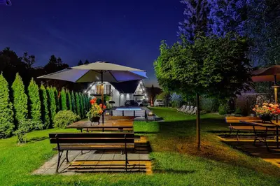 a group of benches and tables with an umbrella at Noclegi u Nawary in Rabka