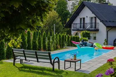 a pool with a bench and a dog in the water at Noclegi u Nawary in Rabka