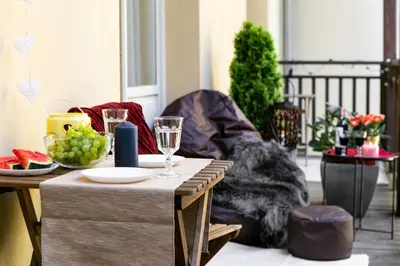 a table with wine glasses and fruit on a balcony at Otium Old Town Sarego in Kraków