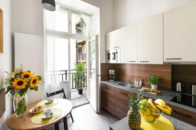 a kitchen with white cabinets and a table with fruits at Otium Old Town Sarego in Kraków