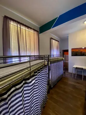 a room with two beds and a table at Ametyst Hostel in Kraków