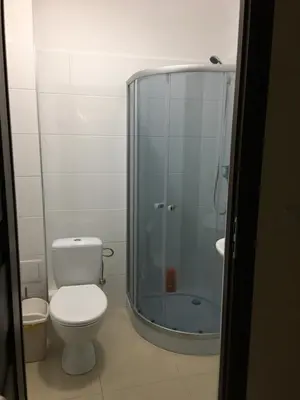 a bathroom with a toilet and a glass shower at Ametyst Hostel in Kraków