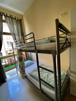 two bunk beds in a room with a window at Ametyst Hostel in Kraków