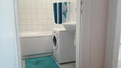 a bathroom with a washing machine next to a sink at Studio Krakowski Styl in Kraków