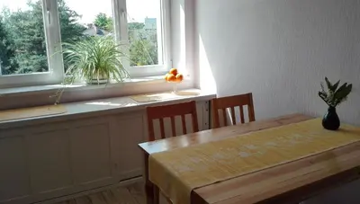a dining room with a table and two windows at Studio Krakowski Styl in Kraków