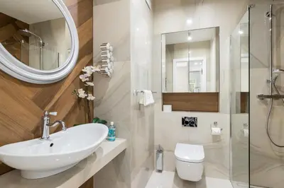 a bathroom with a sink and a toilet and a mirror at Glossy Apart W19 in Kraków