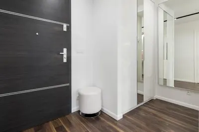 a bathroom with a black door and a trash can at Glossy Apart W19 in Kraków
