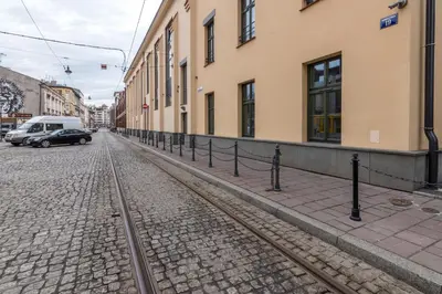 a street with a train track next to a building at Glossy Apart W19 in Kraków