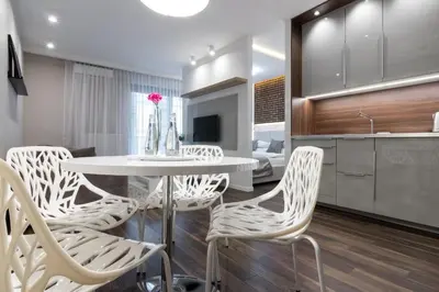 a dining room with a white table and chairs at Glossy Apart W19 in Kraków