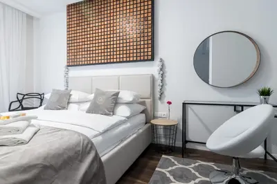 a bedroom with a bed and a mirror and a chair at Glossy Apart W19 in Kraków