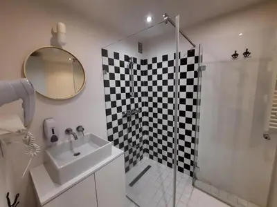a bathroom with a shower and a sink and a mirror at Lorf Hostel&Coffee in Kraków
