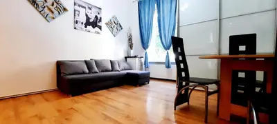 a living room with a black couch and a desk at Lorf Hostel&Coffee in Kraków