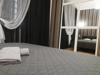 a bedroom with a large bed and a mirror at Lorf Hostel&Coffee in Kraków