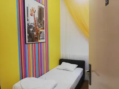 a small bedroom with a bed and a painting of a giraffe at Lorf Hostel&Coffee in Kraków