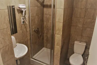 a bathroom with a shower with a toilet and a sink at Lorf Hostel&Coffee in Kraków