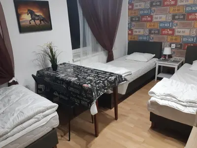 a room with two beds and a table in it at Lorf Hostel&Coffee in Kraków