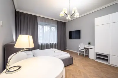 a bedroom with a bed and a desk and a tv at RentPlanet - Studio Krasińskiego in Kraków