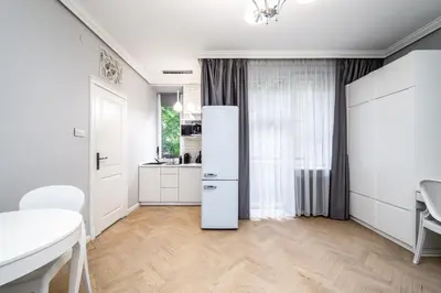 a white kitchen with a refrigerator in a room at RentPlanet - Studio Krasińskiego in Kraków