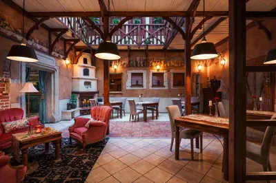 a large room with tables and chairs in a building at Hotel Zameczek in Książ Wielki