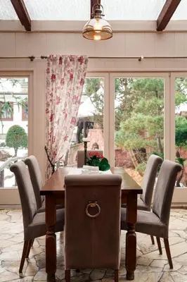 a dining room with a wooden table and chairs at Hotel Zameczek in Książ Wielki