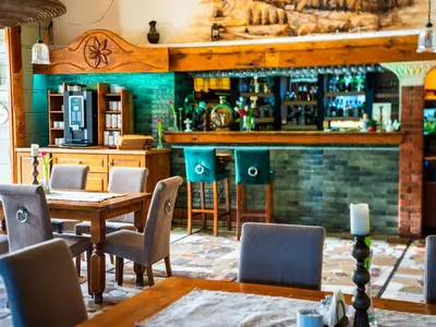 a restaurant with a table and chairs and a bar at Hotel Zameczek in Książ Wielki