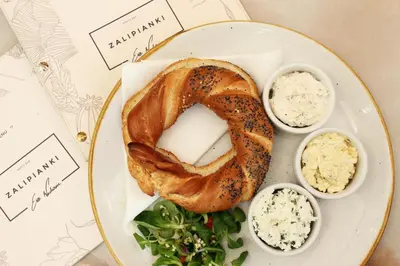 a plate of food with a bagel and some dips at SZEWSKA 22 BOUTIQUE in Kraków
