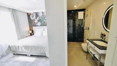 a bedroom with a bed and a bathroom with a sink at SZEWSKA 22 BOUTIQUE in Kraków