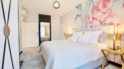 a bedroom with a white bed and a painting on the wall at SZEWSKA 22 BOUTIQUE in Kraków