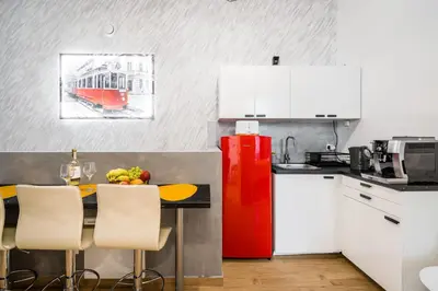 a kitchen with white cabinets and a red refrigerator at Royal City Apartments Old Town in Kraków