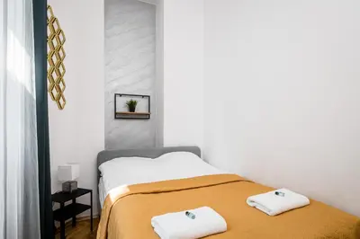 a bedroom with a bed with two towels on it at Royal City Apartments Old Town in Kraków