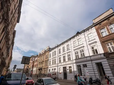 a large white building on a city street with cars at Royal City Apartments Old Town in Kraków