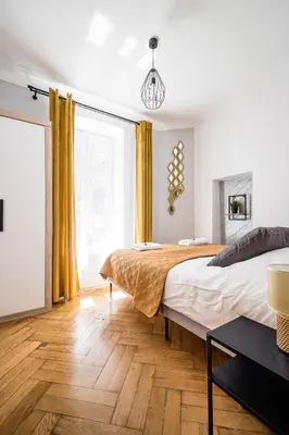 a bedroom with two beds and yellow curtains at Royal City Apartments Old Town in Kraków
