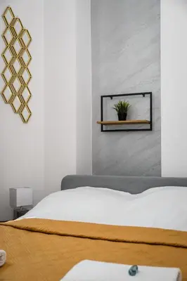 a bedroom with a bed and a plant on a shelf at Royal City Apartments Old Town in Kraków