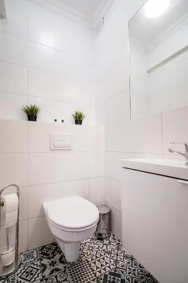 a white bathroom with a toilet and a sink at Royal City Apartments Old Town in Kraków
