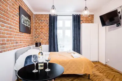 a bedroom with a bed and two wine glasses on a table at Royal City Apartments Old Town in Kraków