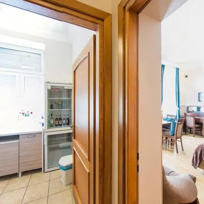 a kitchen with a door open to a living room at Apartamenty Kajzer in Kraków