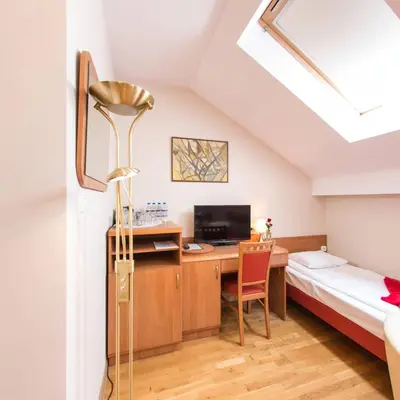a room with a desk and a bed and a desk at Apartamenty Kajzer in Kraków