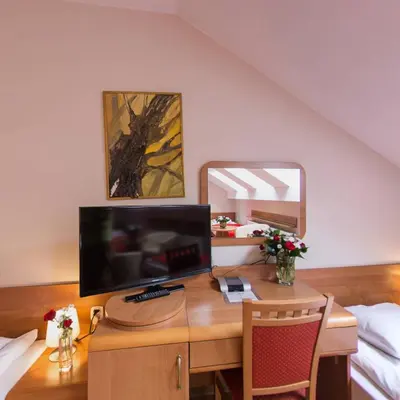 a bedroom with a desk with a computer and a mirror at Apartamenty Kajzer in Kraków