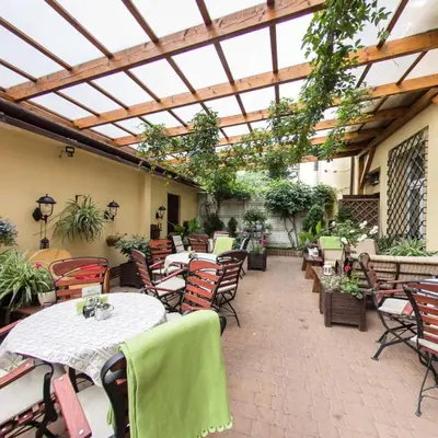 a patio with tables and chairs and a glass roof at Apartamenty Kajzer in Kraków