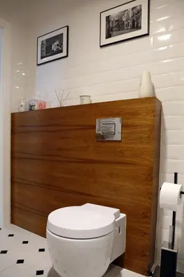 a bathroom with a toilet and a wooden wall at Grey Apartments Kościuszko in Kraków