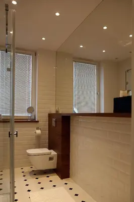 a bathroom with a toilet and a counter and two windows at Grey Apartments Kościuszko in Kraków