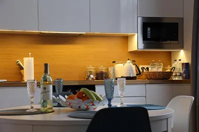 a kitchen with a table with a bottle of wine at Grey Apartments Kościuszko in Kraków