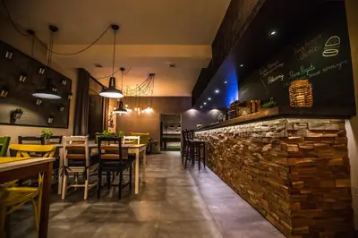 a restaurant with a stone bar with tables and chairs at Pod Kolumnami in Pilica