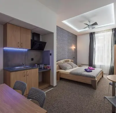 a small room with a bed and a kitchen at 70s Hostel in Kraków