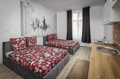 a bed in a room with a large window at 70s Hostel in Kraków